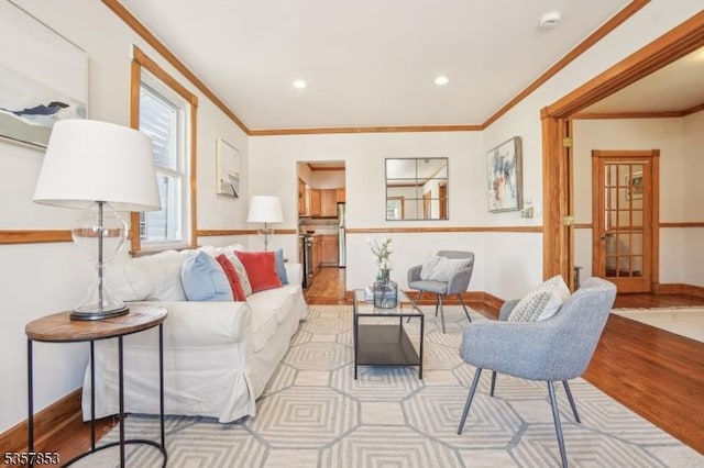 living area featuring light wood finished floors, ornamental molding, baseboards, and recessed lighting