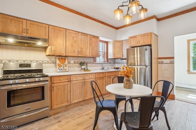 kitchen with stainless steel appliances, under cabinet range hood, light countertops, a sink, and light wood-type flooring