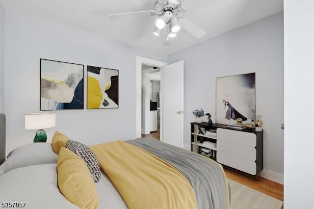 bedroom with wood finished floors, ceiling fan, and baseboards