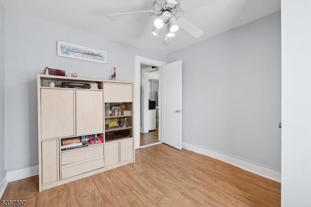 unfurnished bedroom featuring light wood-style floors, baseboards, and a ceiling fan