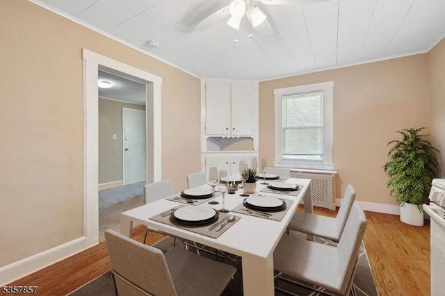 dining space featuring crown molding, ceiling fan, wood finished floors, and baseboards