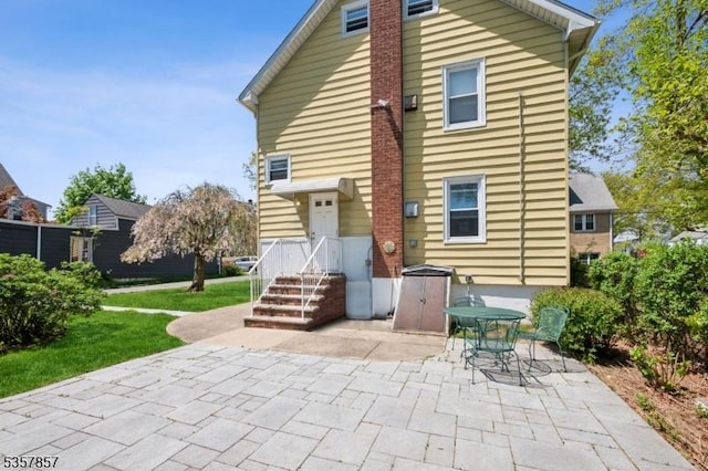 back of property featuring a patio area and a yard