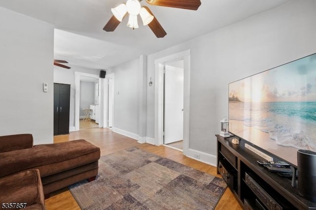 living area with ceiling fan, wood finished floors, and baseboards
