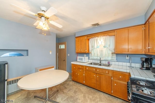 25 Pequannock Ave, Pequannock Twp, NJ 07440 - kitchen featuring a sink, white microwave, range with gas cooktop, radiator, and brown cabinets