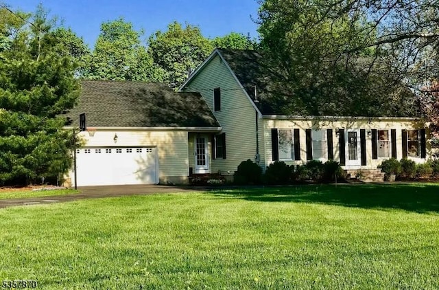 view of front of house featuring a garage, a front lawn, and driveway