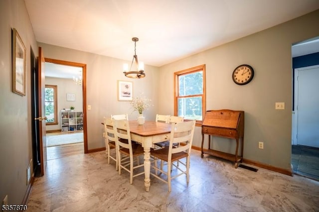 dining room featuring a chandelier and baseboards