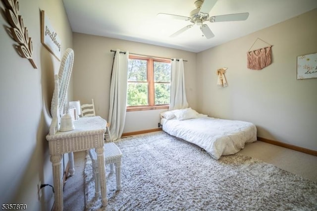 carpeted bedroom with baseboards and a ceiling fan