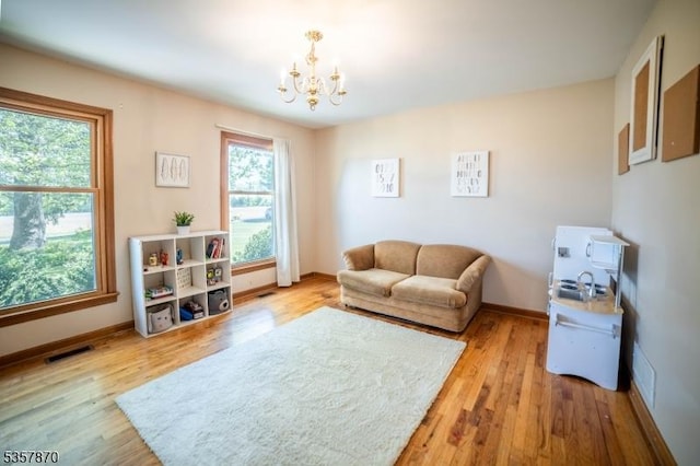living room featuring a chandelier, wood finished floors, and baseboards