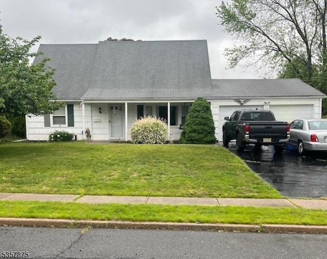 cape cod house with an attached garage, a front yard, and asphalt driveway