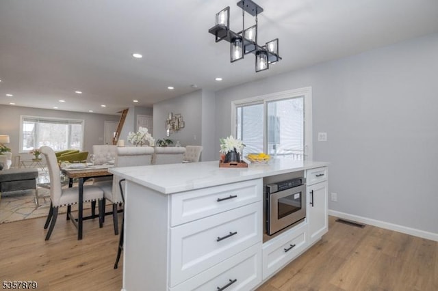 7 Winslow Ave, East Brunswick Twp, NJ 08816 - kitchen featuring open floor plan, light wood-style flooring, white cabinets, recessed lighting, and decorative light fixtures