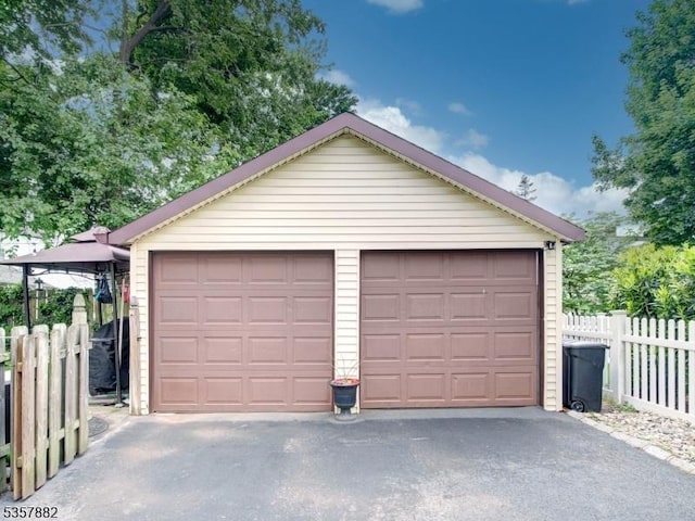 detached garage featuring fence