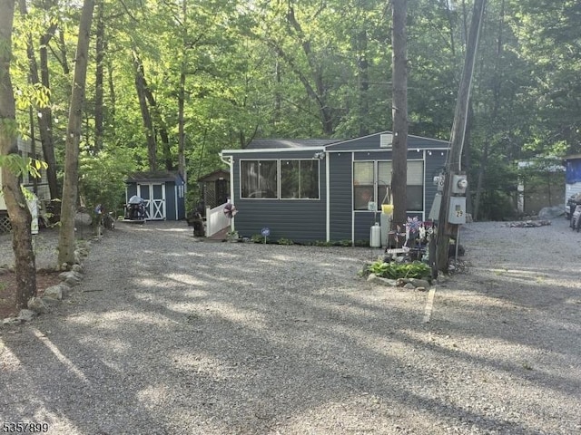 30 Hemlock Vlg, Vernon Twp, NJ 07461 - view of front of home with a storage shed, a forest view, and driveway