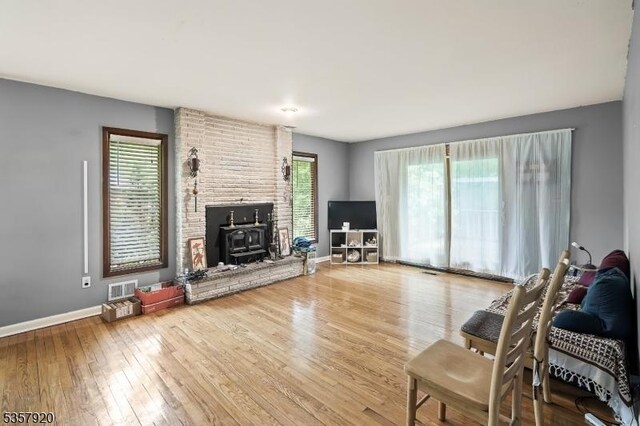 1474 Thomas Ave, North Brunswick Twp, NJ 08902 - living area with hardwood / wood-style floors, baseboards, and a wood stove