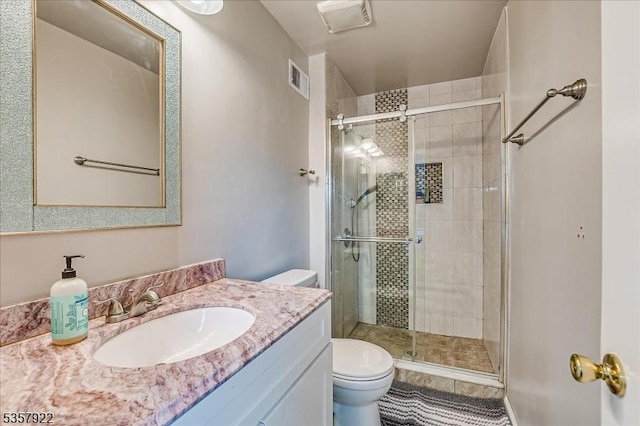 bathroom with toilet, a shower stall, vanity, and tile patterned flooring