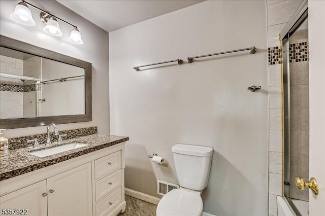 bathroom with baseboards, toilet, vanity, and shower / bath combination with glass door