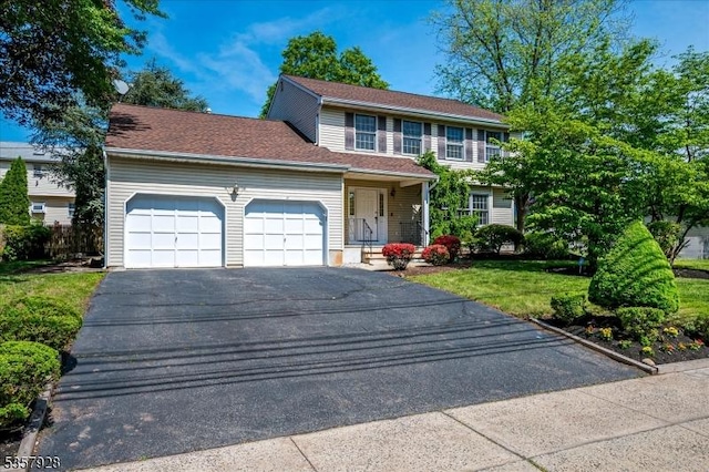 view of front of house featuring a garage, asphalt driveway, and a front yard