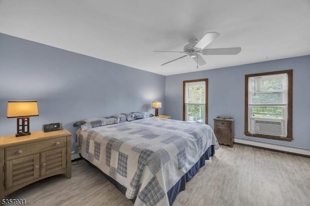 bedroom with light wood-style flooring, baseboard heating, and ceiling fan