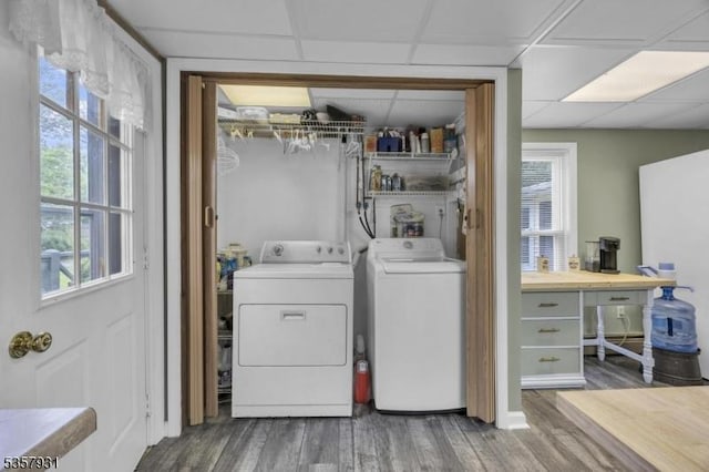 clothes washing area featuring separate washer and dryer, wood finished floors, and a desk