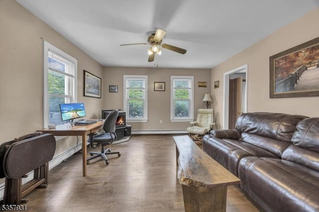 office area featuring healthy amount of natural light, a ceiling fan, baseboard heating, and dark wood-type flooring