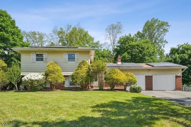 12 Xenia Ct, Mine Hill Twp, NJ 07803 - view of front of house with solar panels, concrete driveway, brick siding, a front lawn, and an attached garage