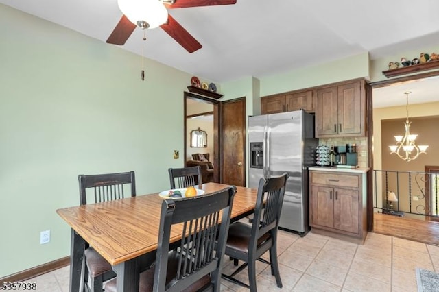 dining area featuring light tile patterned floors, a chandelier, and a ceiling fan