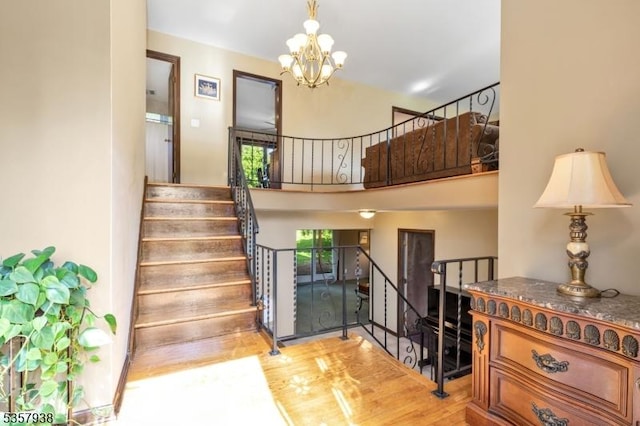 stairs featuring a chandelier and wood finished floors