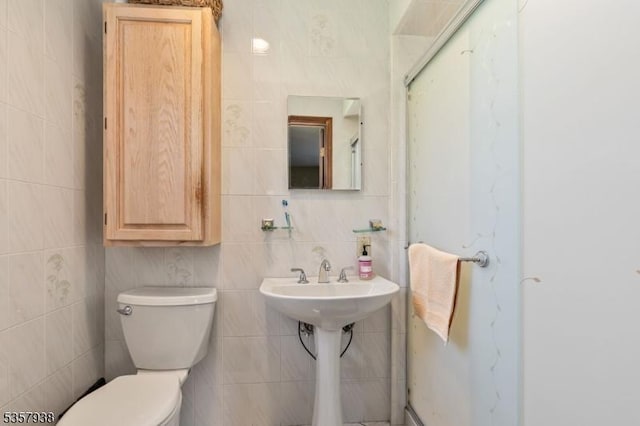 bathroom with tile walls and toilet