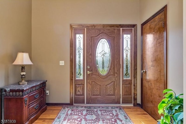 foyer entrance featuring light wood-style floors and baseboards