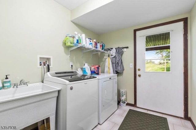 washroom featuring separate washer and dryer, light tile patterned floors, and baseboards