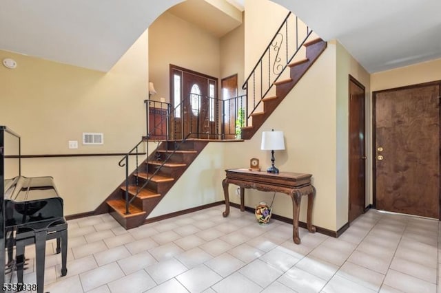 entryway featuring stairway, baseboards, and arched walkways
