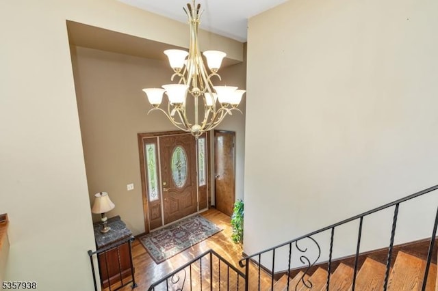 foyer featuring wood finished floors, a chandelier, and a high ceiling