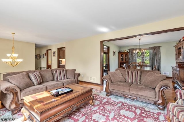 living room with a chandelier, wood finished floors, and baseboards