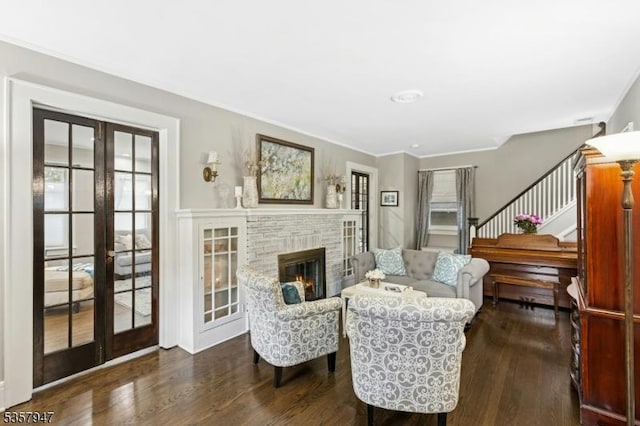living room featuring french doors, wood finished floors, healthy amount of natural light, stairway, and ornamental molding