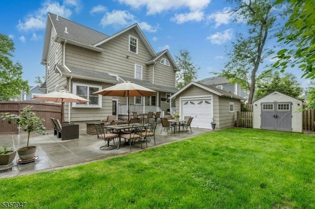 back of property with an outbuilding, a patio, a shed, and a detached garage