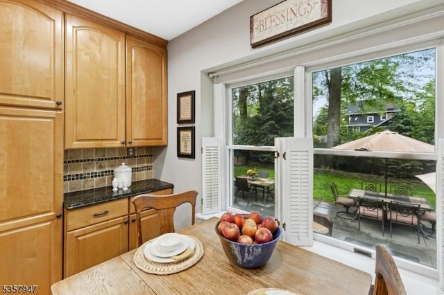 kitchen featuring tasteful backsplash and dark stone countertops