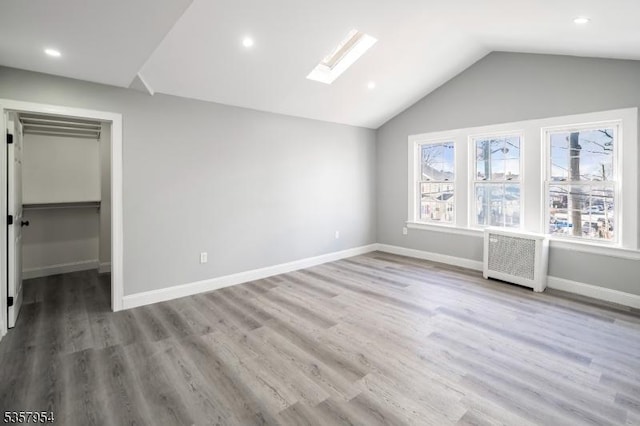 56 Laventhal Ave, Irvington Twp, NJ 07111 - unfurnished bedroom with radiator heating unit, a skylight, vaulted ceiling, wood finished floors, and baseboards