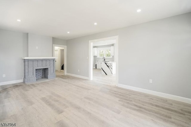 56 Laventhal Ave, Irvington Twp, NJ 07111 - unfurnished living room featuring recessed lighting, baseboards, light wood finished floors, a sink, and a fireplace