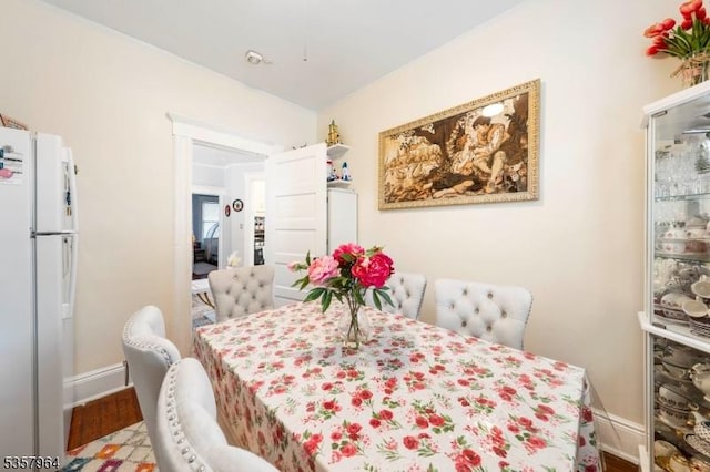 dining space featuring baseboards and wood finished floors