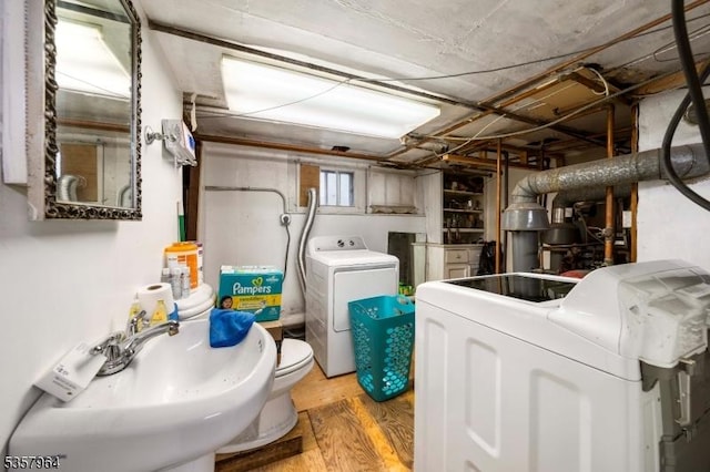 laundry area with separate washer and dryer and light wood-type flooring