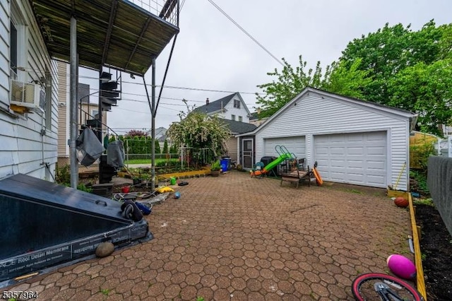 view of patio / terrace featuring an outdoor structure, a garage, fence, cooling unit, and a grill