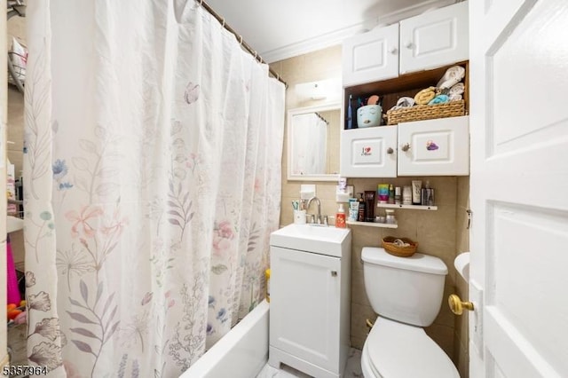 bathroom featuring toilet, tile walls, and vanity