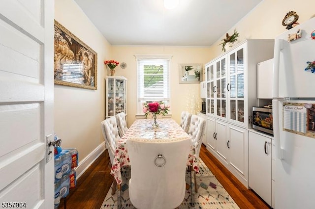 dining area with dark wood finished floors and baseboards