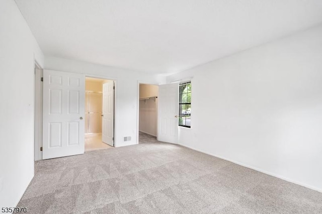 26 Fisher Dr Unit 2704, Franklin Twp, NJ 08823 - unfurnished bedroom featuring light carpet, a spacious closet, and a closet