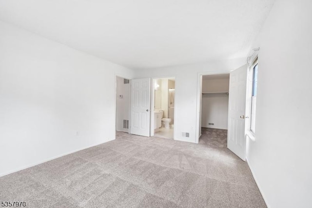 26 Fisher Dr Unit 2704, Franklin Twp, NJ 08823 - unfurnished bedroom with a spacious closet, light colored carpet, ensuite bath, a closet, and baseboards