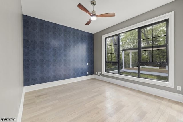 370 Hartshorn Dr, Millburn Twp, NJ 07078 - empty room featuring an accent wall, wallpapered walls, baseboards, wood finished floors, and ceiling fan