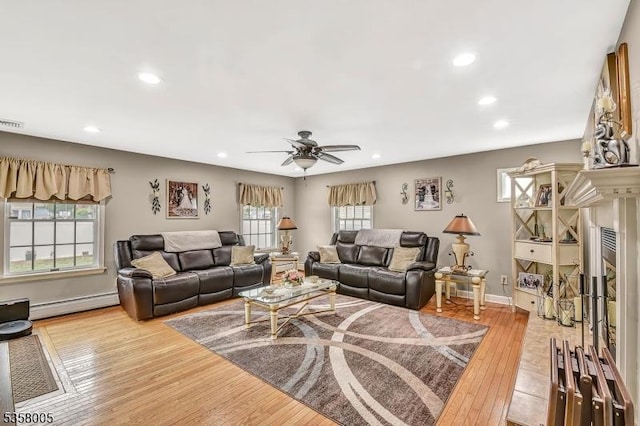 living room with a baseboard radiator, recessed lighting, ceiling fan, light wood-type flooring, and plenty of natural light