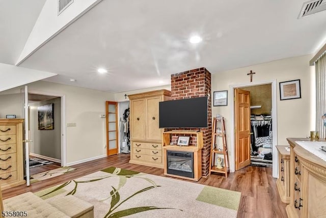 living area with light wood-style flooring, baseboards, recessed lighting, and a fireplace