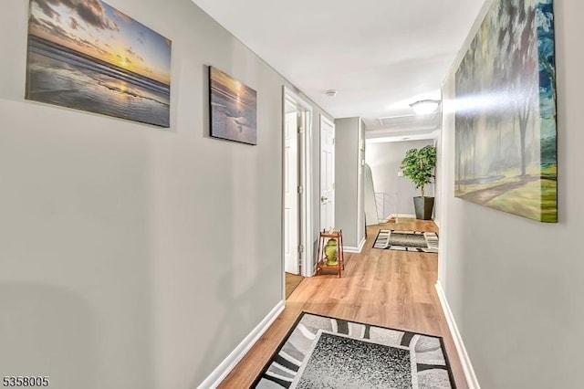 hallway featuring light wood-style floors and baseboards