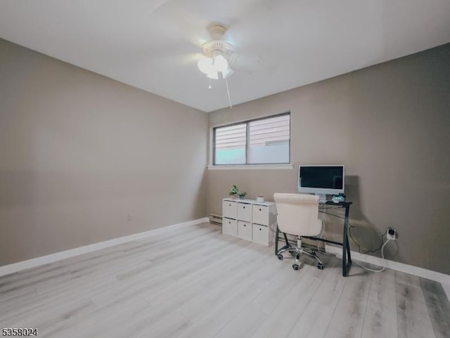 home office with a ceiling fan, baseboards, light wood-type flooring, and a baseboard heating unit