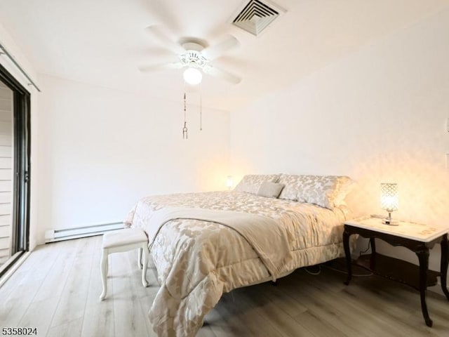 bedroom featuring wood finished floors, a baseboard radiator, and ceiling fan